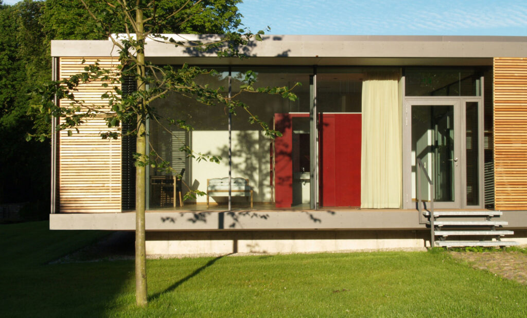 Detailansicht auf Seminargebäude Gut Siggen mit Rasen und kleinem Baum im Vordergrund