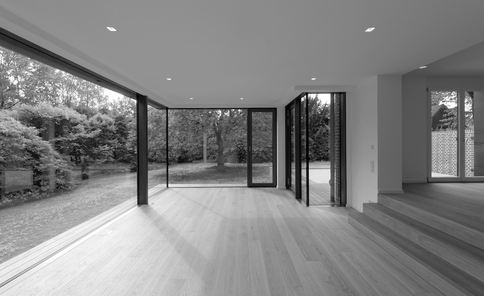 Innenansicht leerer Raum mit Glasfassade und Blick in einen garten in Schwarz-Weiß