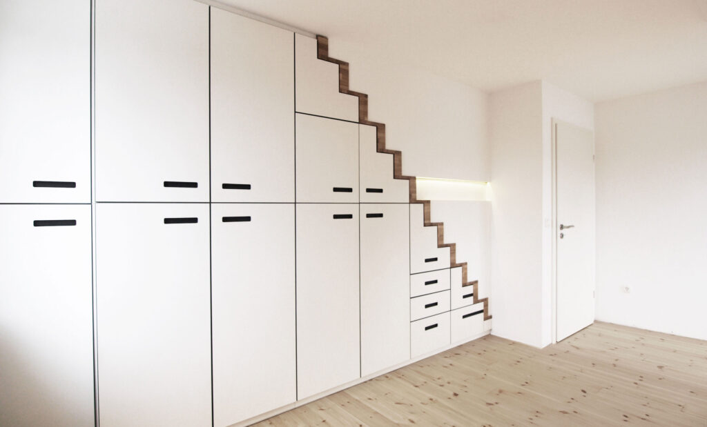 Raum mit Treppenunterbauschrank und einer Tür