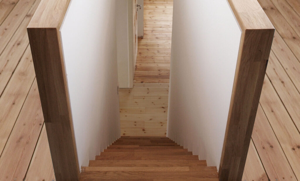 Holztreppe abwärts zwischen zwei weißen Wänden