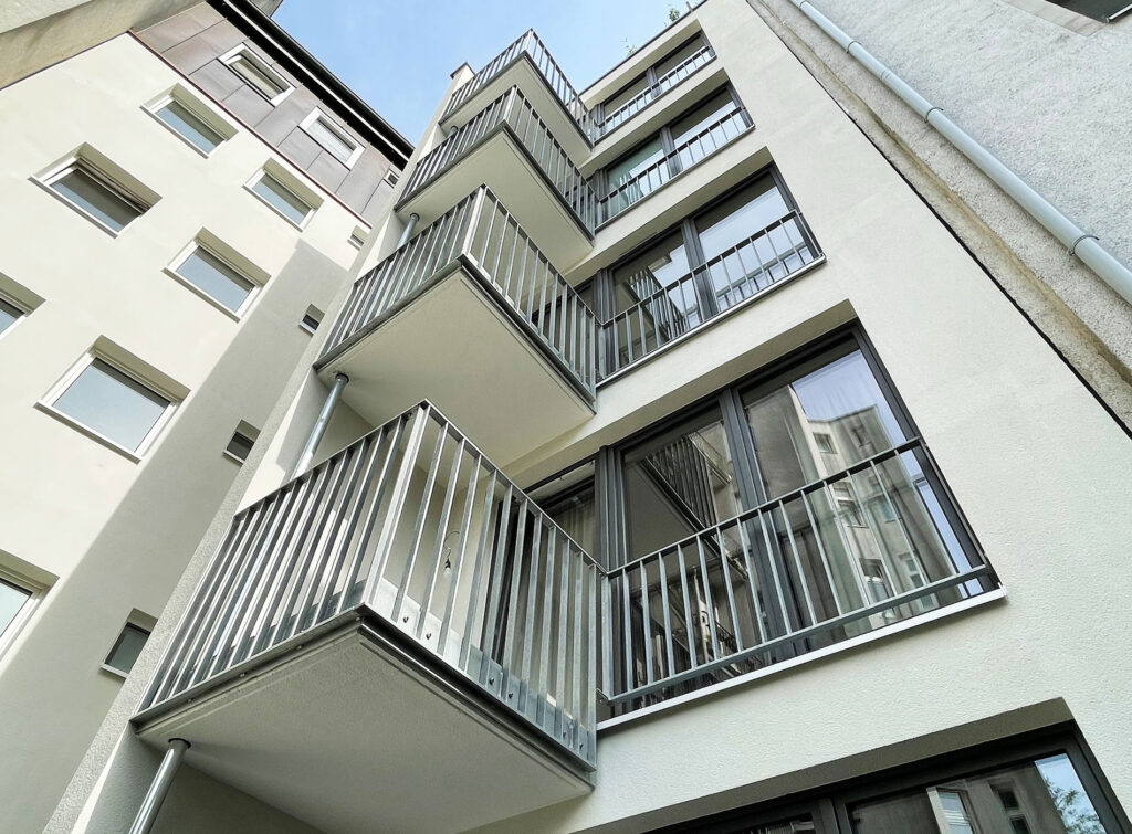 Blick auf eine schmale Hausfassade mit Balkonen