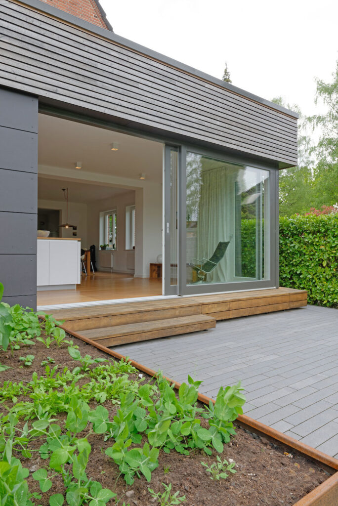 Blick von außen über Terrasse mit geöffneter Tür