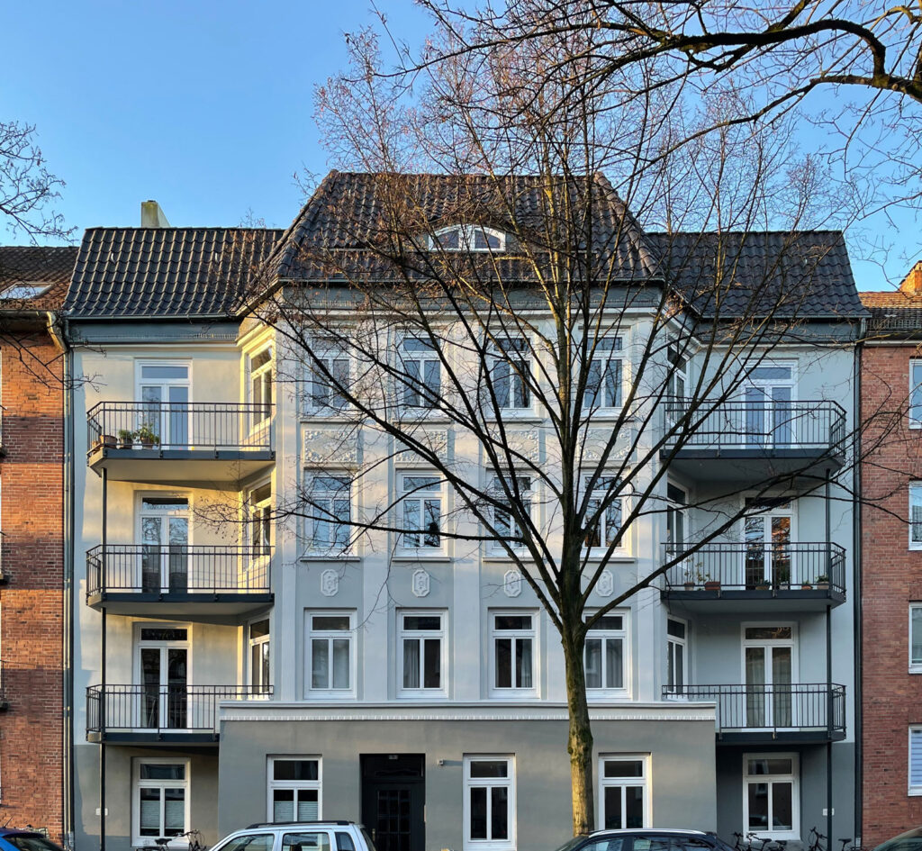 Außenansicht Mehrfamilien-Stadthaus in Hamburg mit Balkonen und Baum im Vordergrund