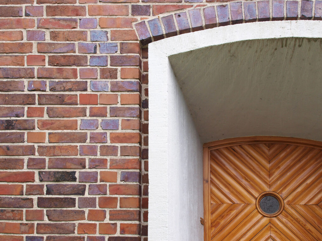 Backsteinmauer mit einer Tür im Anschnitt