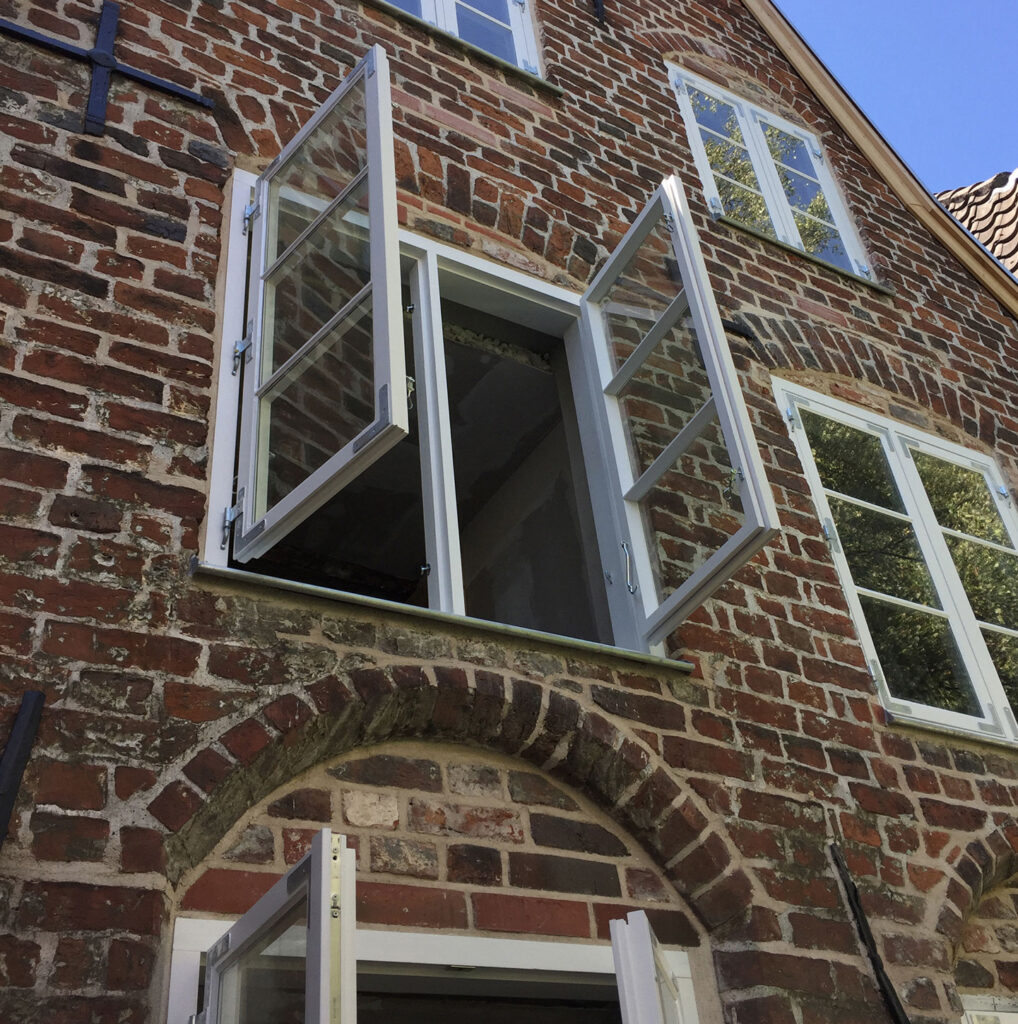 geöffnetes Fenster eines alten Backsteinhauses in Lübeck