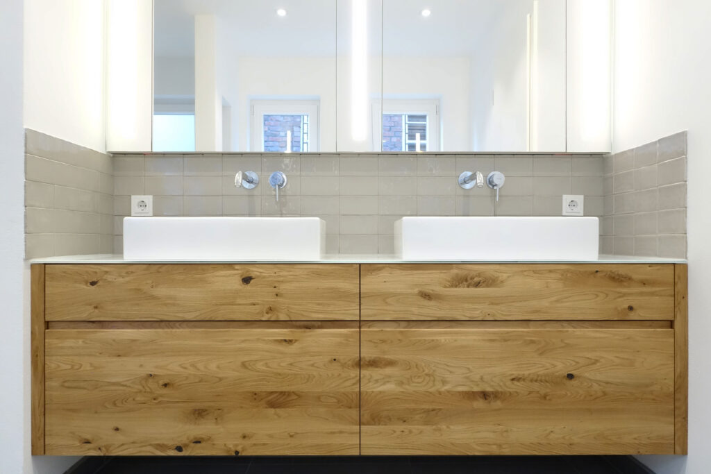 zwei Waschbecken mit Holzverkleidung in einem modernen Bad