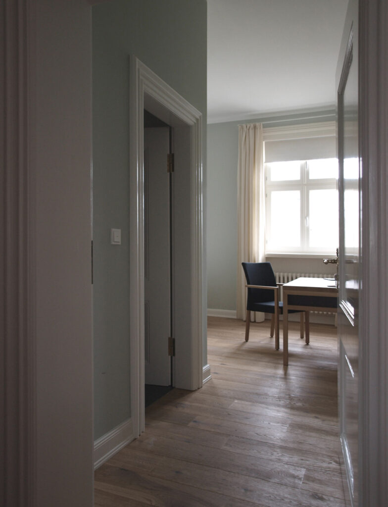 Zimmer mit Stuhl und renovierten Dielen