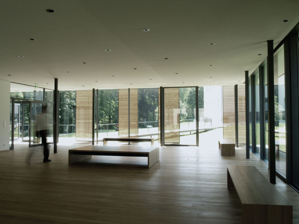 leerer Raum mit Glasfront und Sitzbänken aus Holz