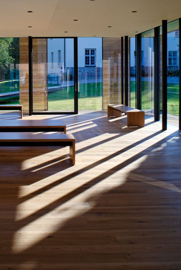 leerer Raum mit Glasfront und Sitzbänken aus Holz