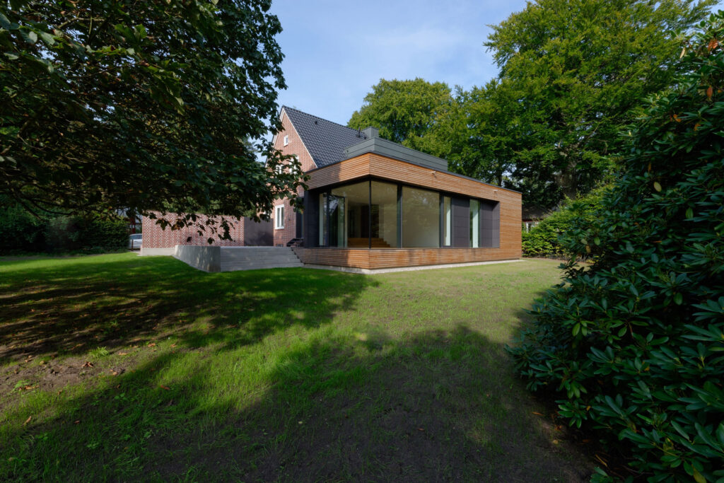 Blick auf flachen Anbau an einem Einfamilienhaus aus Backstein
