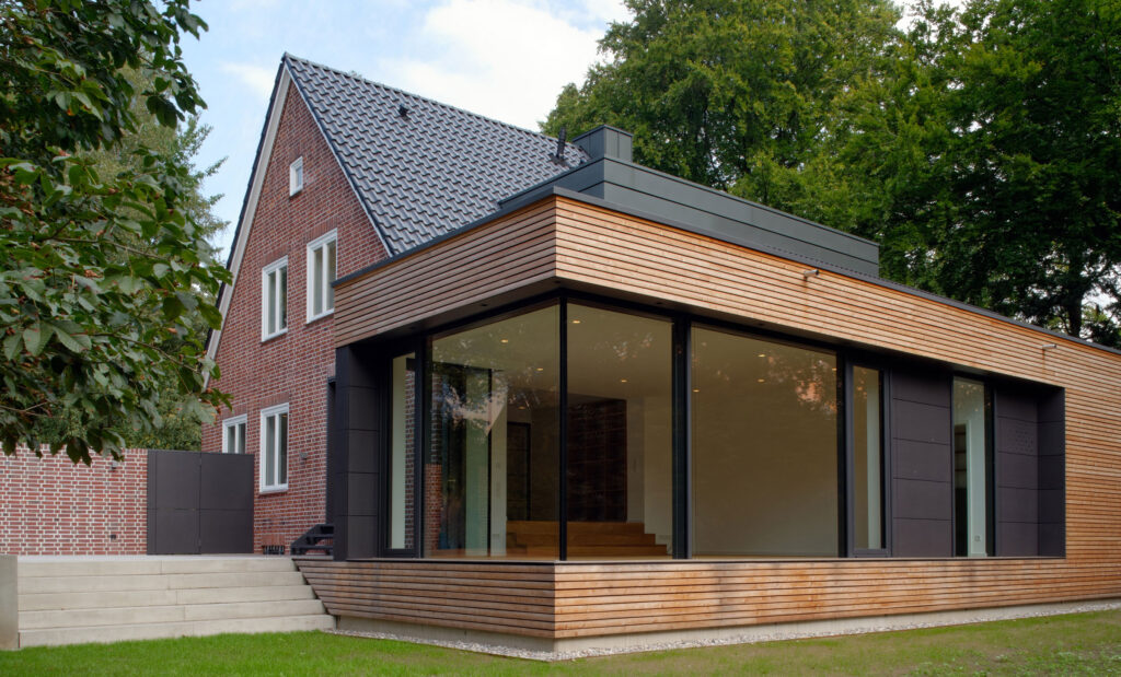 Blick auf flachen Anbau an Einfamilienhaus aus Backstein