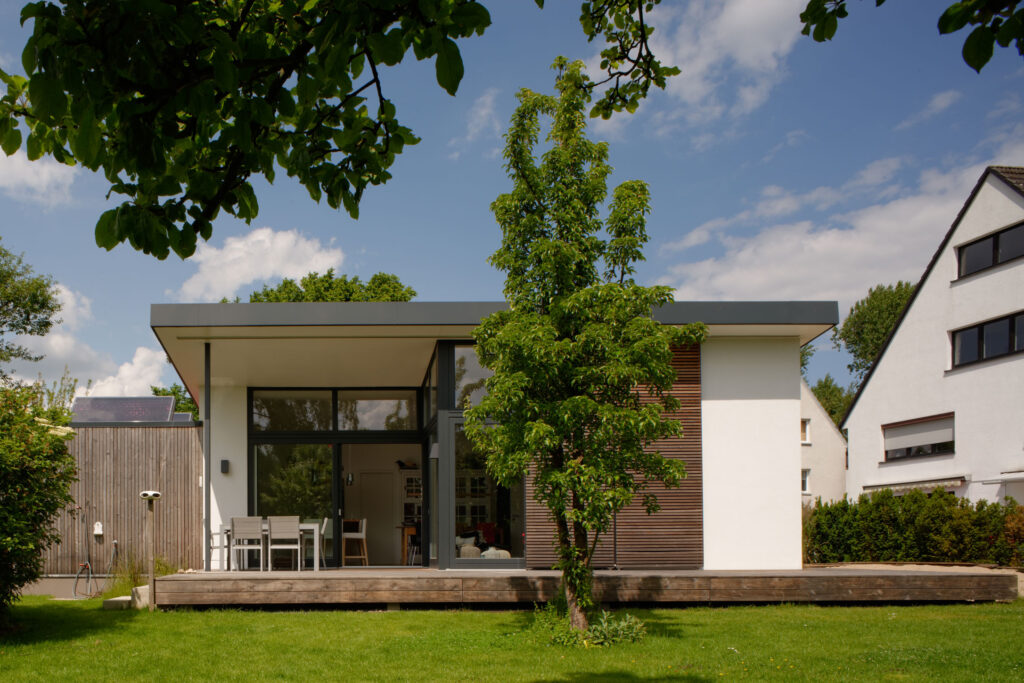 Blick auf modernen Bungalow mit Baum im Vordergrund