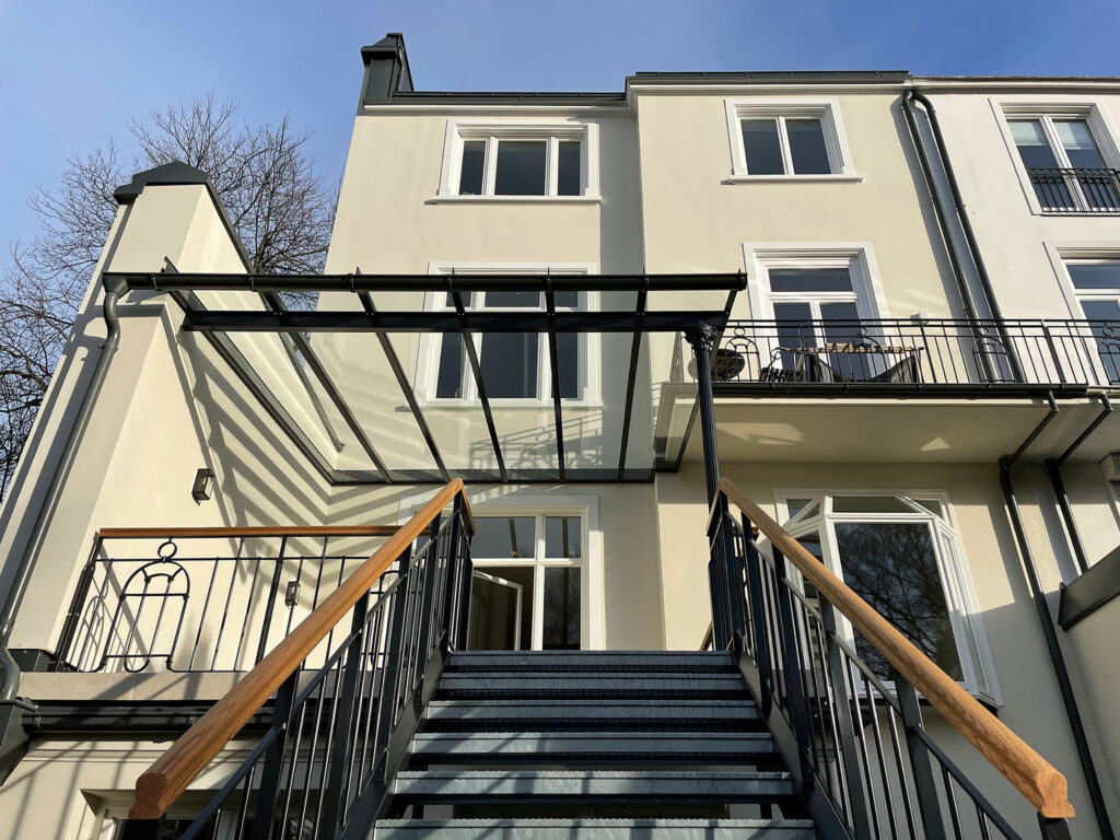 Blick auf Metallterrasse mit Haus im Hintergrund