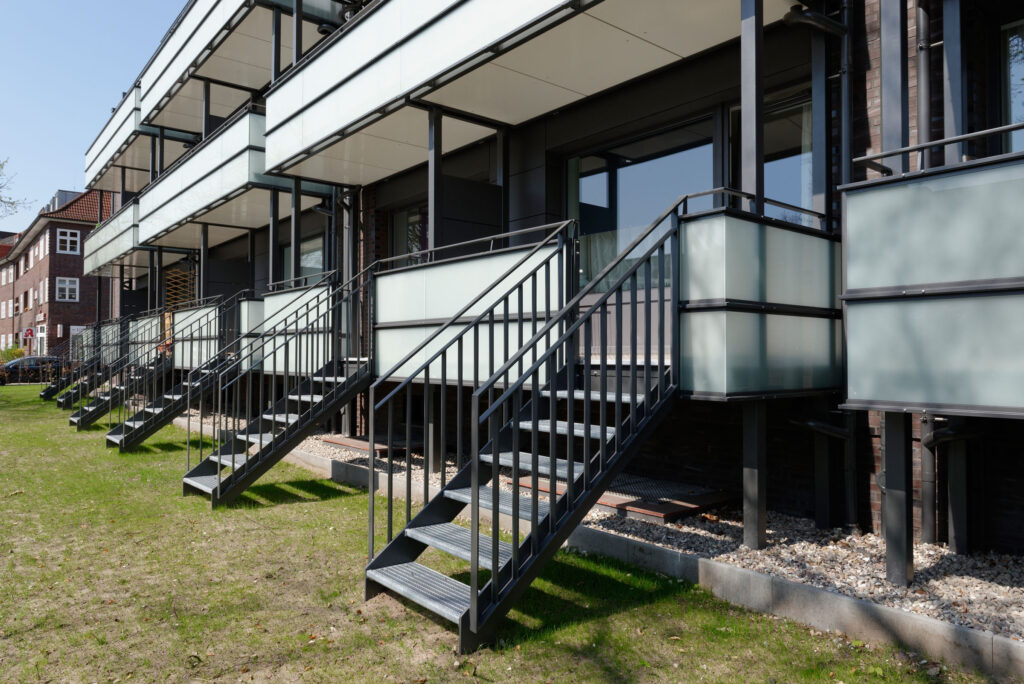 Blick auf Glasbalkone mit Treppen in den Garten