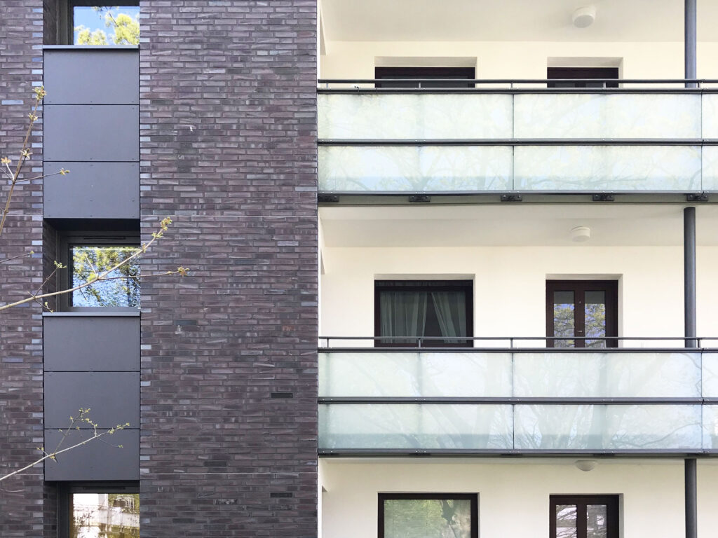 Blick auf Glasbalkone und Klinkerwand eines Mehrfamilienhauses