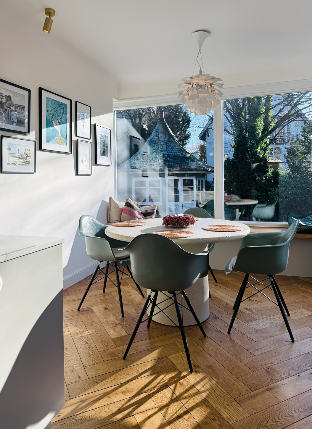 Blick auf eine Sitzgruppe vor großem Fenster in den Garten.