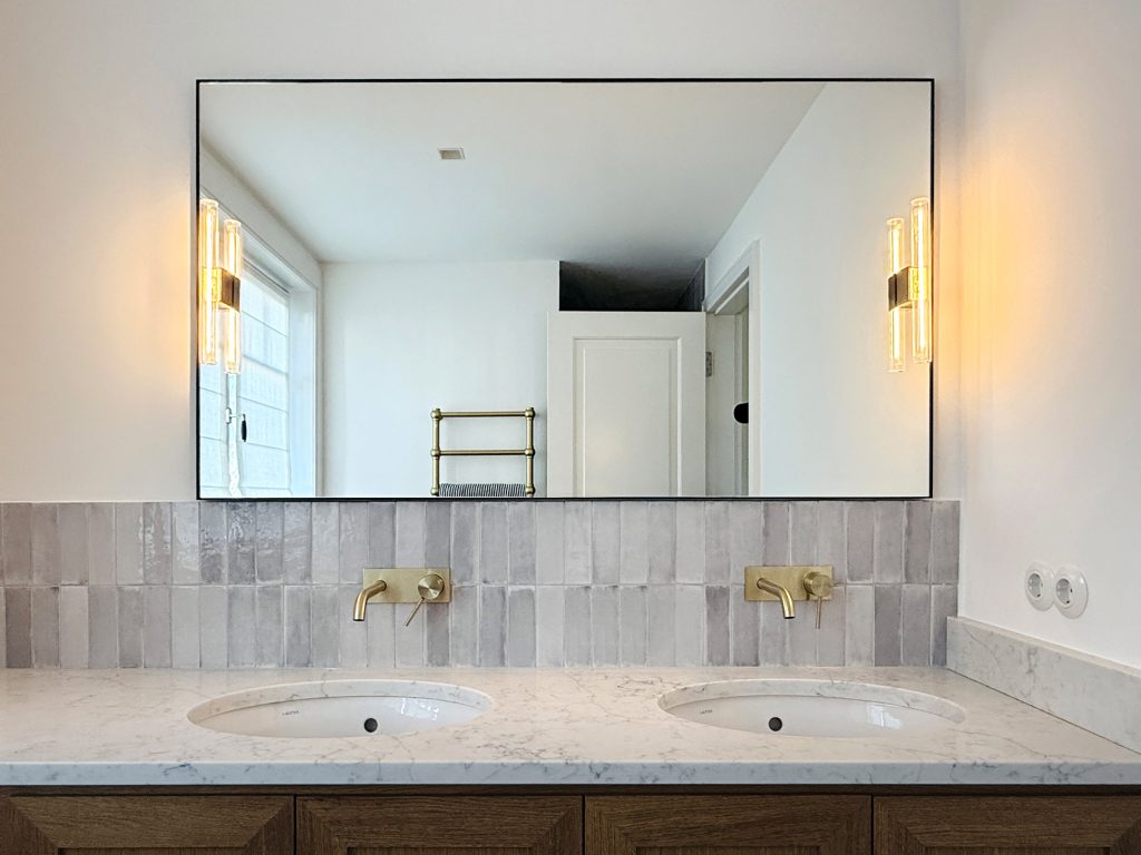 Blick auf einen Waschtisch mit großem Spiegel.