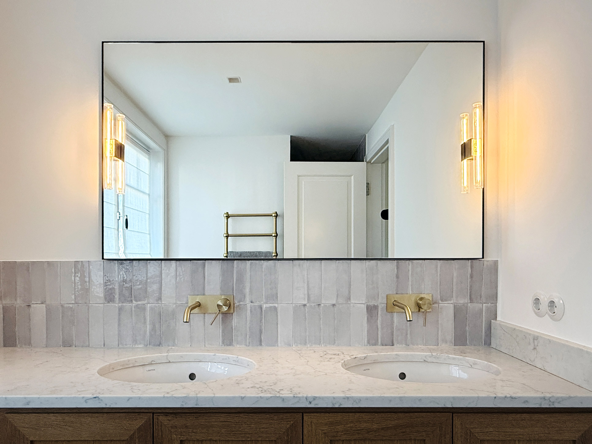 Blick auf einen Waschtisch mit großem Spiegel.