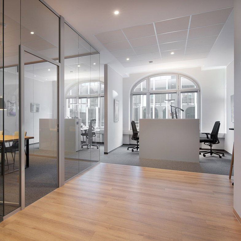 Blick auf einen Empfangstresen. links ist ein Büro durch eine gläserne Trennwand zu erkennen